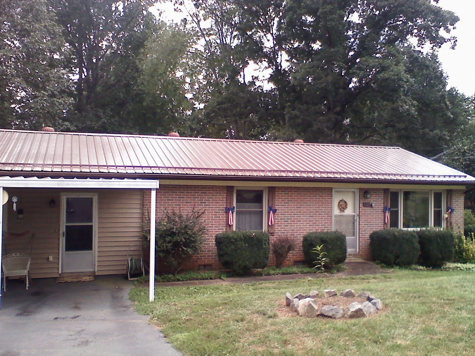 Bronze metal roof and carport on a brick ranch home — Roof Repair work by our crew in Deer Island